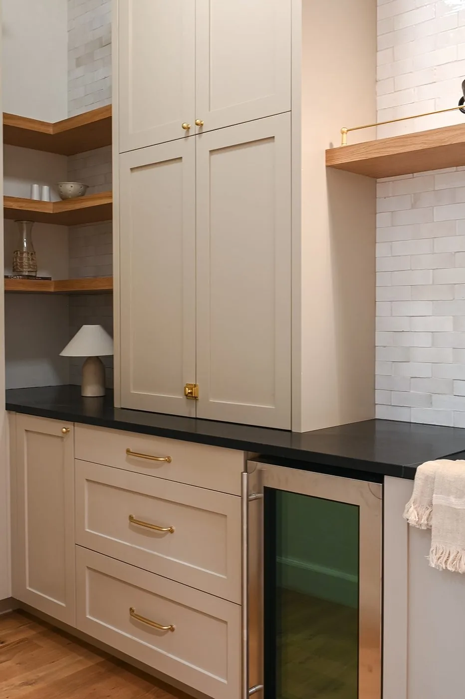 Beverage bar with honed black stone counters and a built in beverage refrigerator